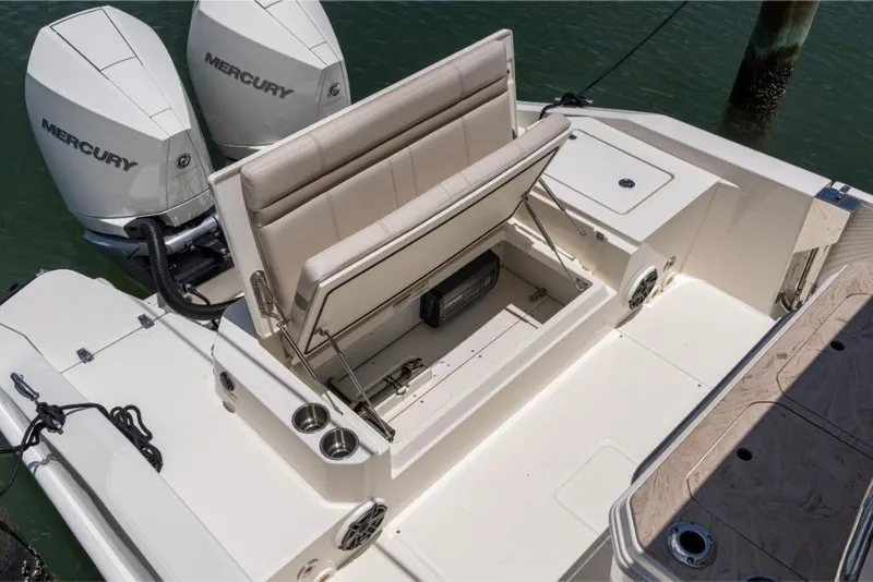 Slide: The Image of 2024 Boston Whaler 280 Dauntless boat with open storage compartment and twin Mercury engines. - 48