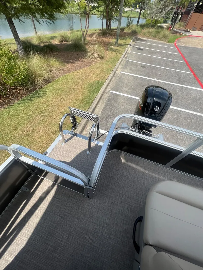 Slide: The Image of 2024 Sun Tracker Party Barge 18 DLX pontoon boat with outboard motor and swim ladder. - 15