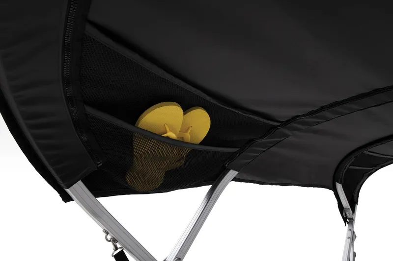 Slide: The Image of Sun Tracker Party Barge 18 DLX 2024 bimini top with storage pocket and yellow flip-flops. - 19