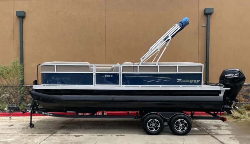 Slide: The Image of 2024 Ranger Reata 200C pontoon boat with Mercury outboard motor on trailer. - 0