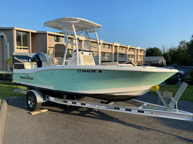 Slide: The Image of 2022 NauticStar 191 Hybrid boat on a Venture trailer in a parking lot. - 12