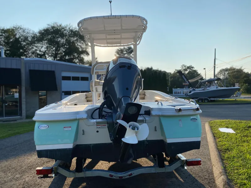 Slide: The Image of 2022 NauticStar 191 Hybrid boat, rear view with outboard motor, parked on a trailer. - 7