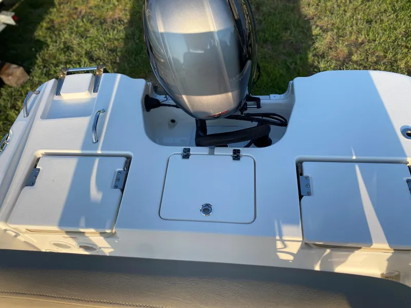 Slide: The Image of 2022 NauticStar 191 Hybrid boat stern with outboard motor and storage compartments. - 8