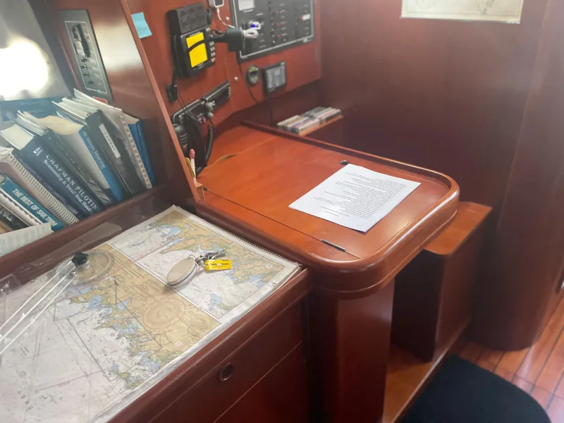 Slide: The Image of Navigation station on a 2002 Beneteau 393 sailboat with charts and books. - 14