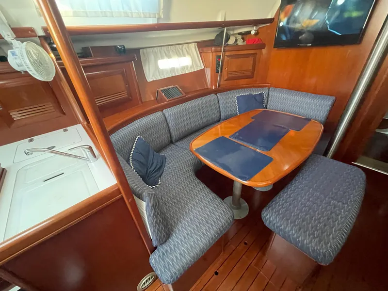 Slide: The Image of Interior of 2002 Beneteau 393 sailboat with dining area and wooden table. - 15