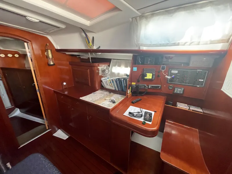 Slide: The Image of Interior of 2002 Beneteau 393 sailboat with navigation station and wooden cabinetry. - 17