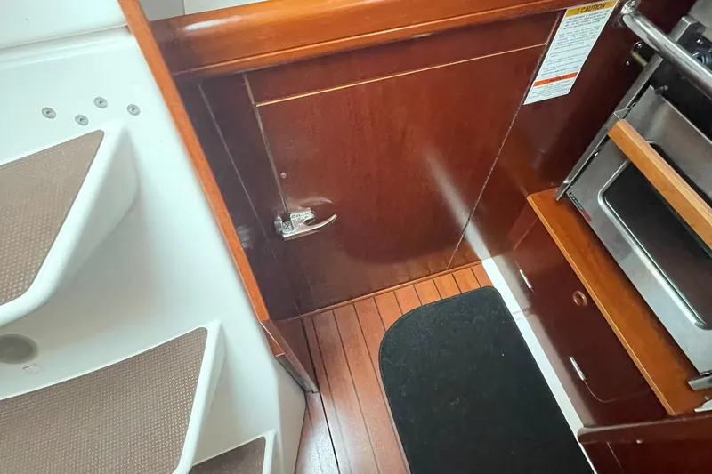 Slide: The Image of Interior of 2002 Beneteau 393 sailboat showing wooden flooring and cabinetry. - 21
