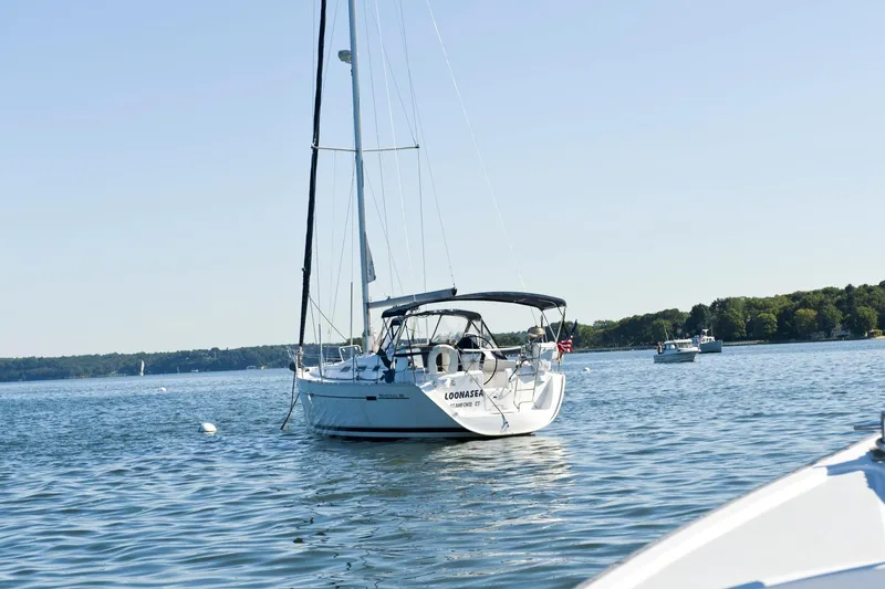 Slide: The Image of Beneteau 393 sailboat from 2002 anchored in a calm bay. - 23