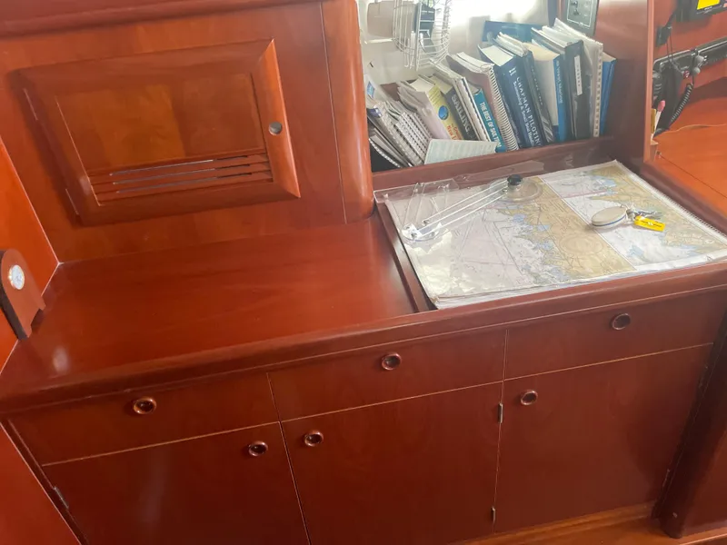 Slide: The Image of Navigation station on a 2002 Beneteau 393 sailboat with chart table and books. - 9