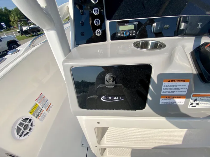 Slide: The Image of 2024 Robalo R232 Explorer boat dashboard with control panel and storage compartment. - 14