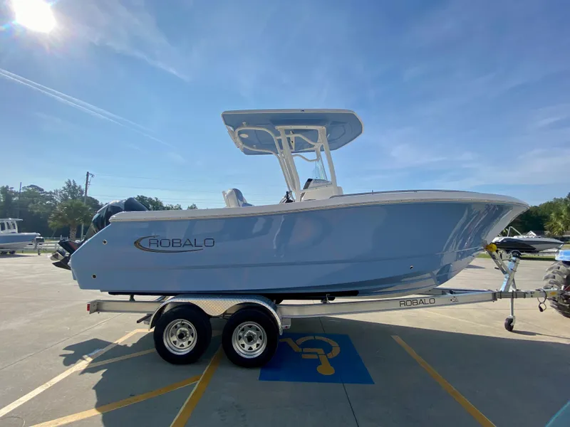 Slide: The Image of 2024 Robalo R232 Explorer boat on a trailer in a parking lot. - 3