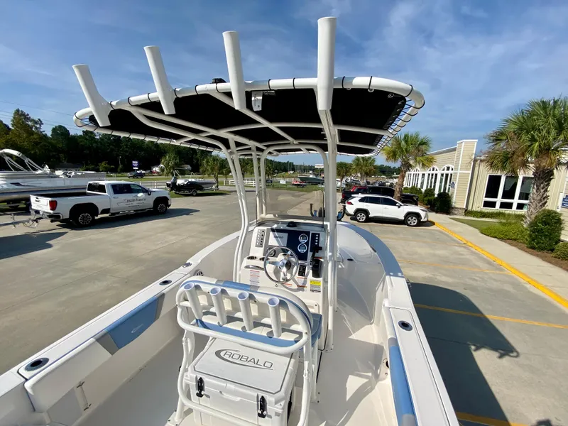 Slide: The Image of 2024 Robalo R180 Center Console boat with T-top in a dealership lot. - 5