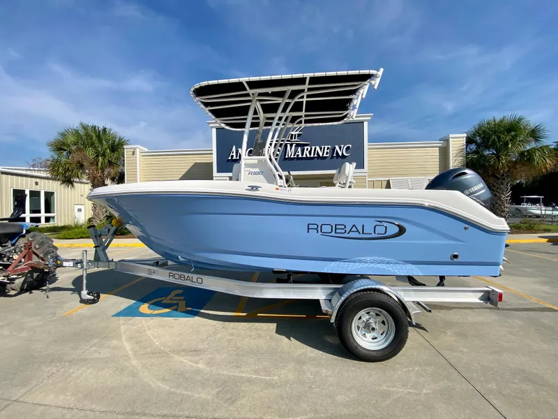 Slide: The Image of 2024 Robalo R180 Center Console boat on trailer in dealership lot. - 0