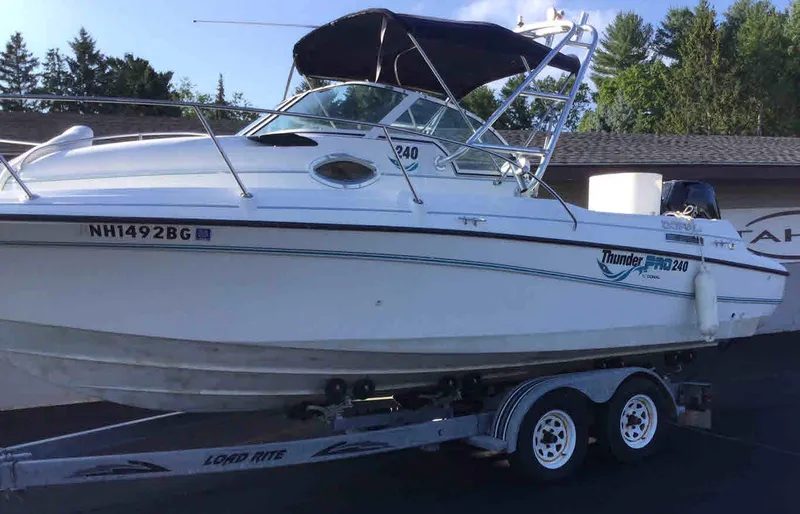 Slide: The Image of 2000 Doral Thunder Pro 240 boat on a trailer with a black canopy. - 3