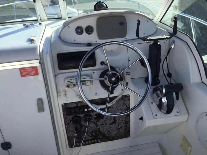 Slide: The Image of Control panel of a 2000 Doral Thunder Pro 240 boat with steering wheel and gauges. - 7
