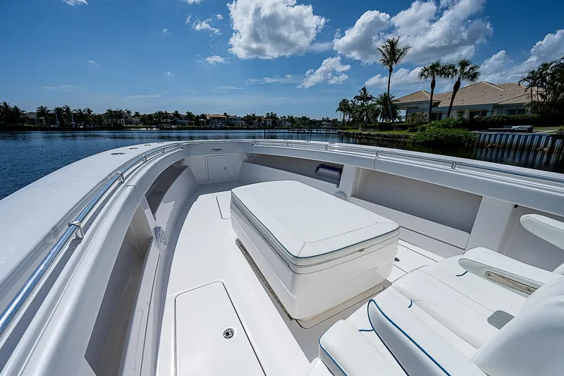Slide: The Image of Invincible 42 boat interior, 2018 model, featuring sleek white seating and open water view. - 10