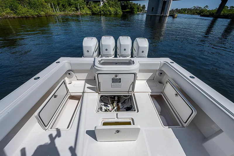 Slide: The Image of Invincible 42 boat deck with open storage compartments, 2018 model, on calm water. - 19