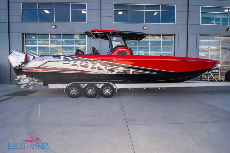 Slide: The Image of 2024 Donzi 39 VRZ boat in red and black on a trailer outside a marina. - 17