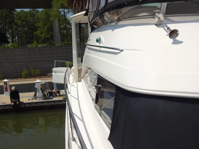 Slide: The Image of 2004 Meridian 408 Motoryacht docked at marina with a person sitting nearby. - 19