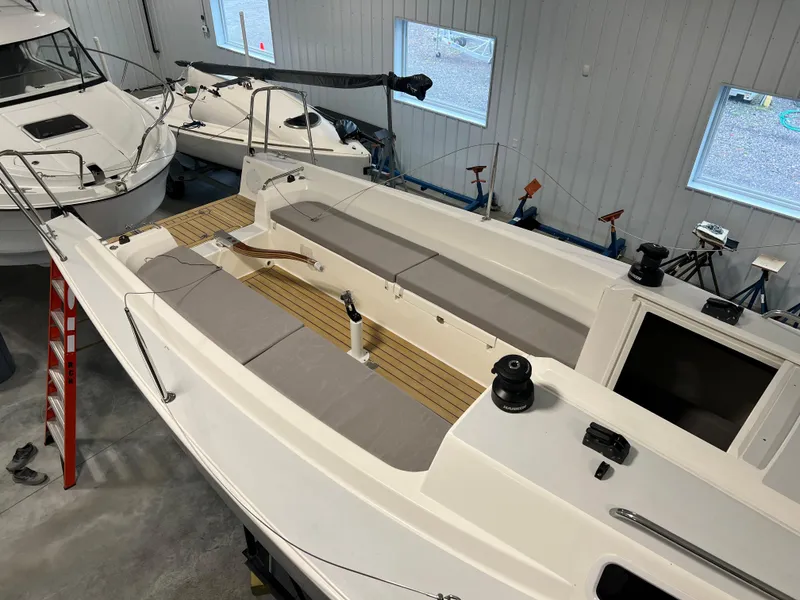 Slide: The Image of 2024 J Boats J/9 sailboat in indoor storage, showcasing deck and seating area. - 2