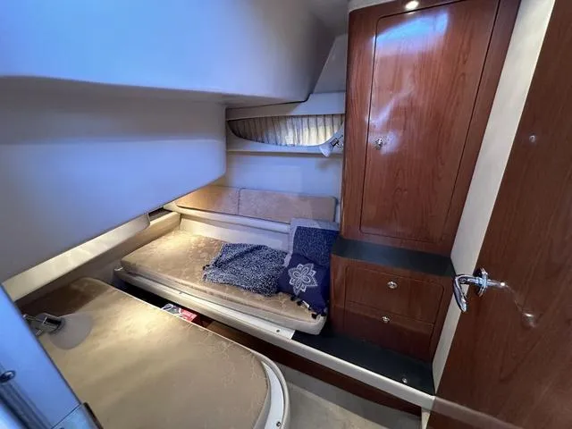 Slide: The Image of 2010 Regal 4080 Flybridge cabin interior with wooden cabinetry and cozy bedding. - 9