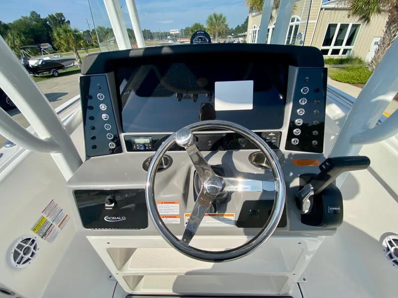 Slide: The Image of 2024 Robalo R232 Explorer boat dashboard with steering wheel and control panel. - 12