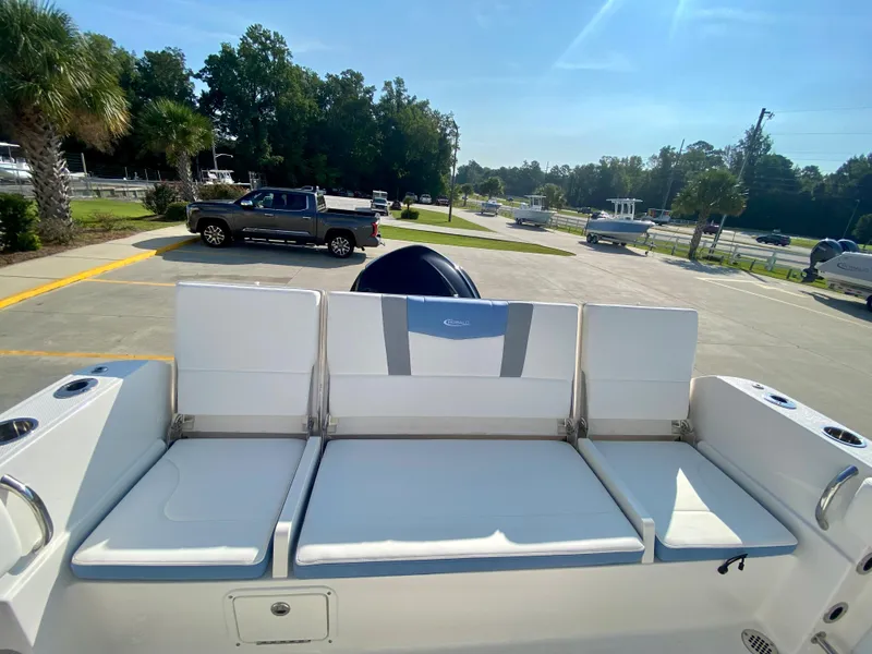 Slide: The Image of 2024 Robalo R232 Explorer boat with cushioned seating in a parking lot. - 8