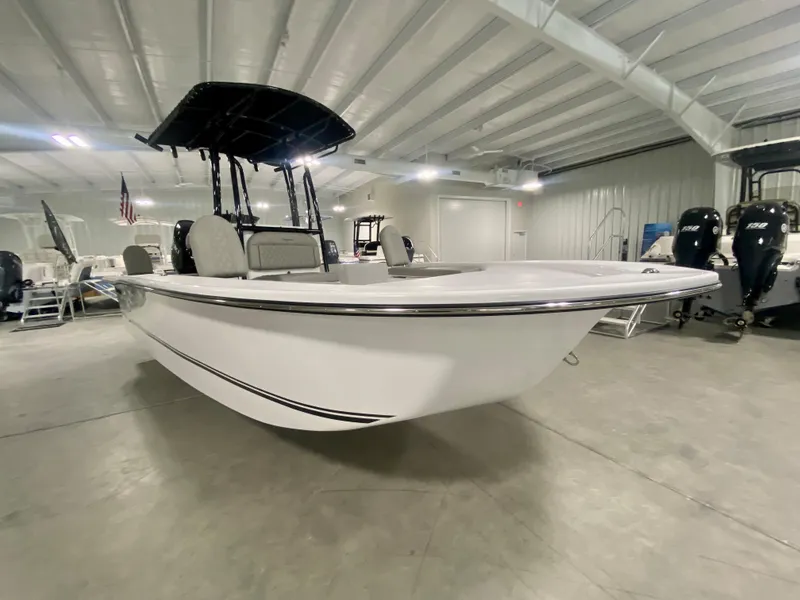 Slide: The Image of 2024 Savannah SS21 boat in showroom, white hull, black T-top, modern design. - 4