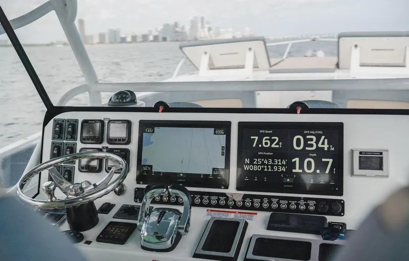Slide: The Image of YachtCat 41 cockpit with navigation screens and controls, 2024 model, city skyline in background. - 13