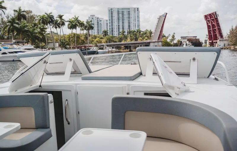 Slide: The Image of 2024 YachtCat 41 on waterway with open hatches, cityscape, and drawbridge in background. - 14