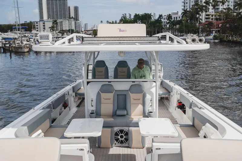 Slide: The Image of 2024 YachtCat 41 on water, featuring spacious deck and seating, with cityscape in background. - 17