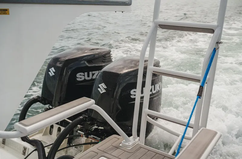 Slide: The Image of Twin Suzuki outboard engines on 2024 YachtCat 41, with ladder and ocean backdrop. - 21