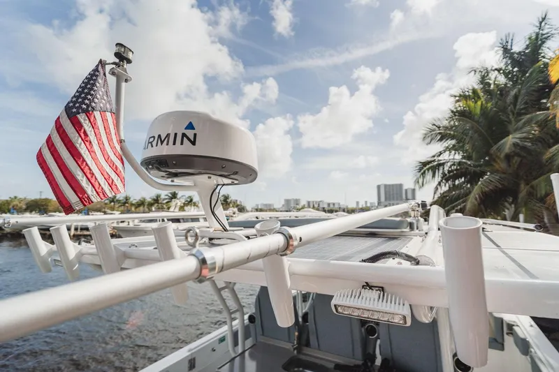Slide: The Image of 2024 YachtCat 41 with Garmin radar and American flag, docked near palm trees and cityscape. - 6