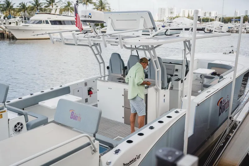 Slide: The Image of 2024 YachtCat 41 docked, featuring spacious deck and modern design, with person onboard. - 8