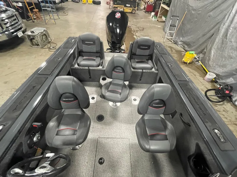 Slide: The Image of 2021 Tracker Targa V-18 WT boat interior with seating and motor in a garage. - 15