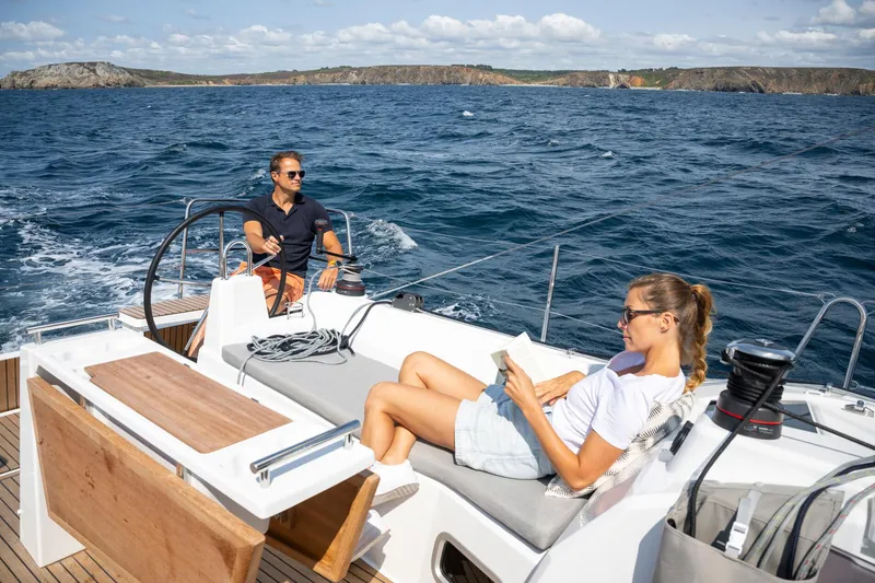 Slide: The Image of 2025 Beneteau Oceanis 37.1 sailing with two people relaxing on deck. - 7
