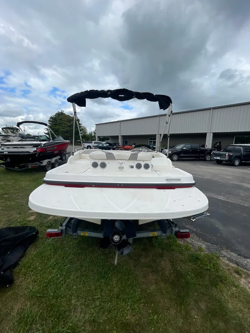 Slide: The Image of 2011 Bayliner 197 boat with canopy, parked outdoors near other boats and vehicles. - 9