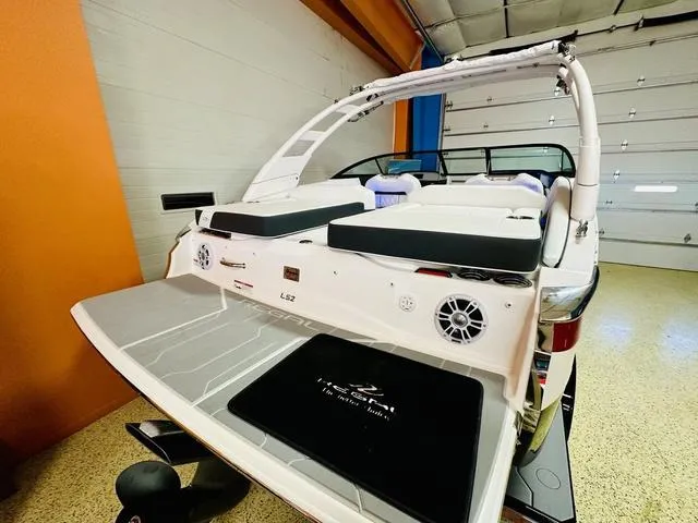 Slide: The Image of 2024 Regal LS2 boat in showroom, rear view with swim platform and seating. - 6