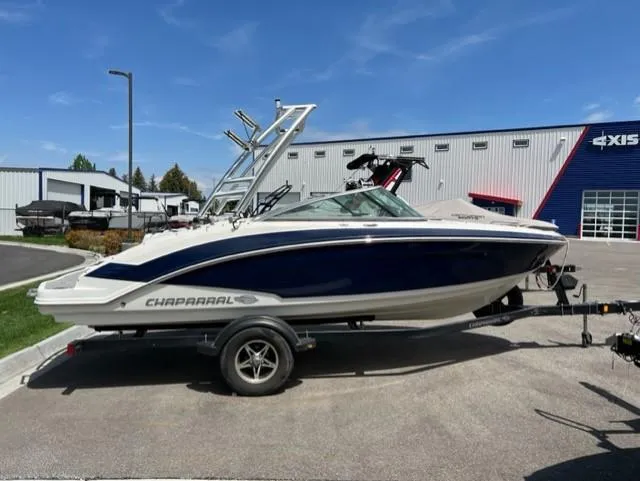Slide: The Image of 2015 Chaparral 203VR boat on trailer, parked outdoors near a building. - 2