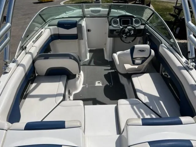 Slide: The Image of 2015 Chaparral 203VR boat interior with white and blue seating, steering console, and open deck. - 9