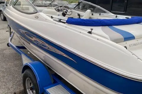 Slide: The Image of 2009 Stingray 195 LX boat on trailer, featuring blue and white design. - 4