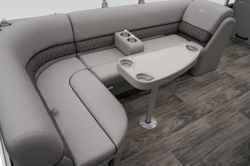 Slide: The Image of 2024 Ranger Reata 223C boat interior with gray cushioned seating and table. - 43