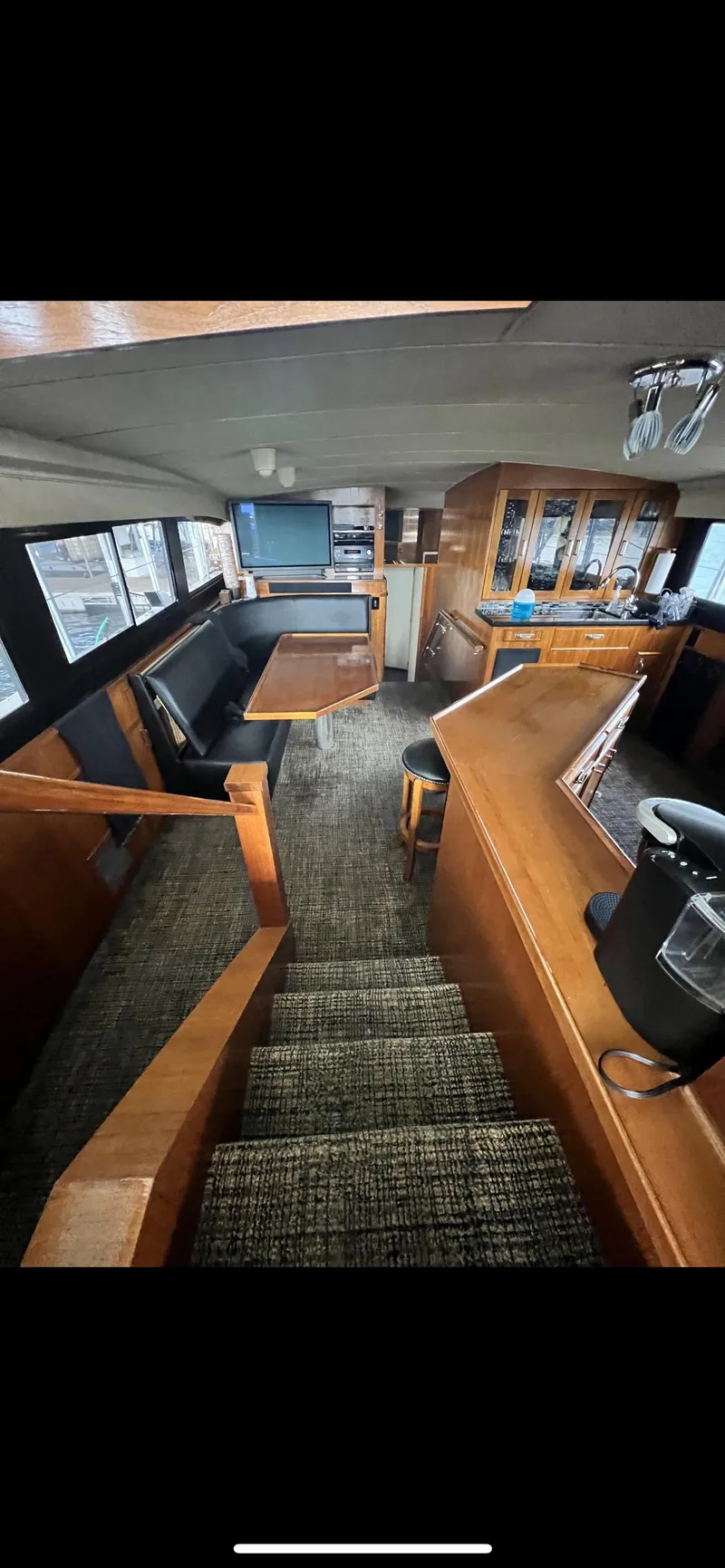 Slide: The Image of Interior of 1982 Bertram 58 Fly yacht with wooden furnishings and carpeted flooring. - 10