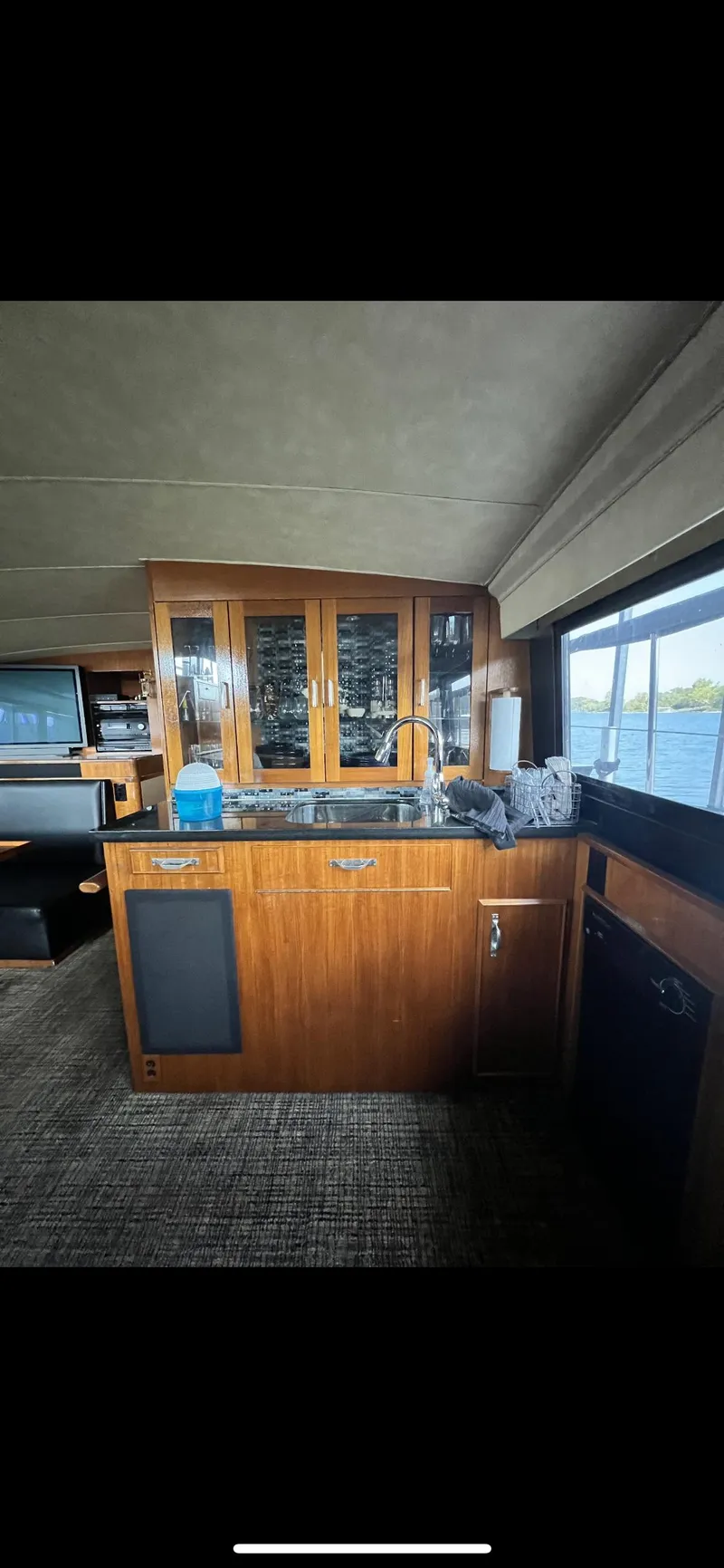 Slide: The Image of Interior of 1982 Bertram 58 Fly yacht with wooden cabinetry and large windows. - 11