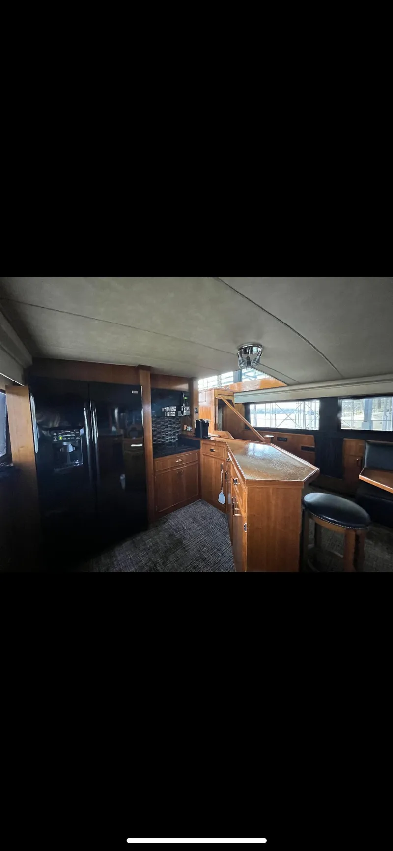 Slide: The Image of Interior of 1982 Bertram 58 Fly yacht with modern kitchen and seating area. - 12