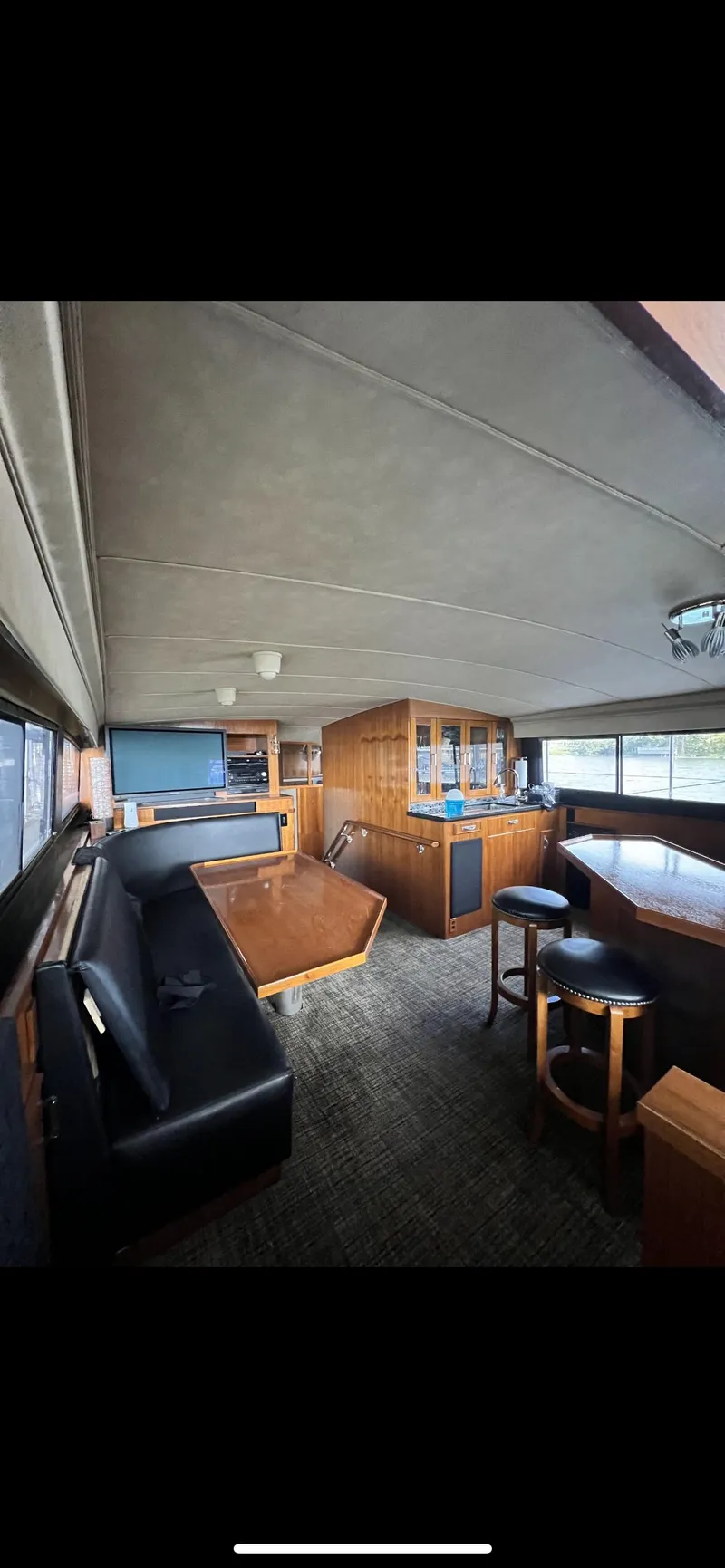 Slide: The Image of Interior of a 1982 Bertram 58 Fly yacht with wooden furnishings and seating area. - 13