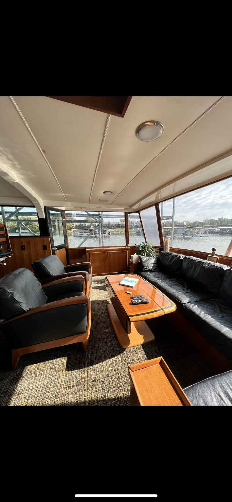 Slide: The Image of Interior of 1982 Bertram 58 Fly yacht with leather seating and wooden table. - 4