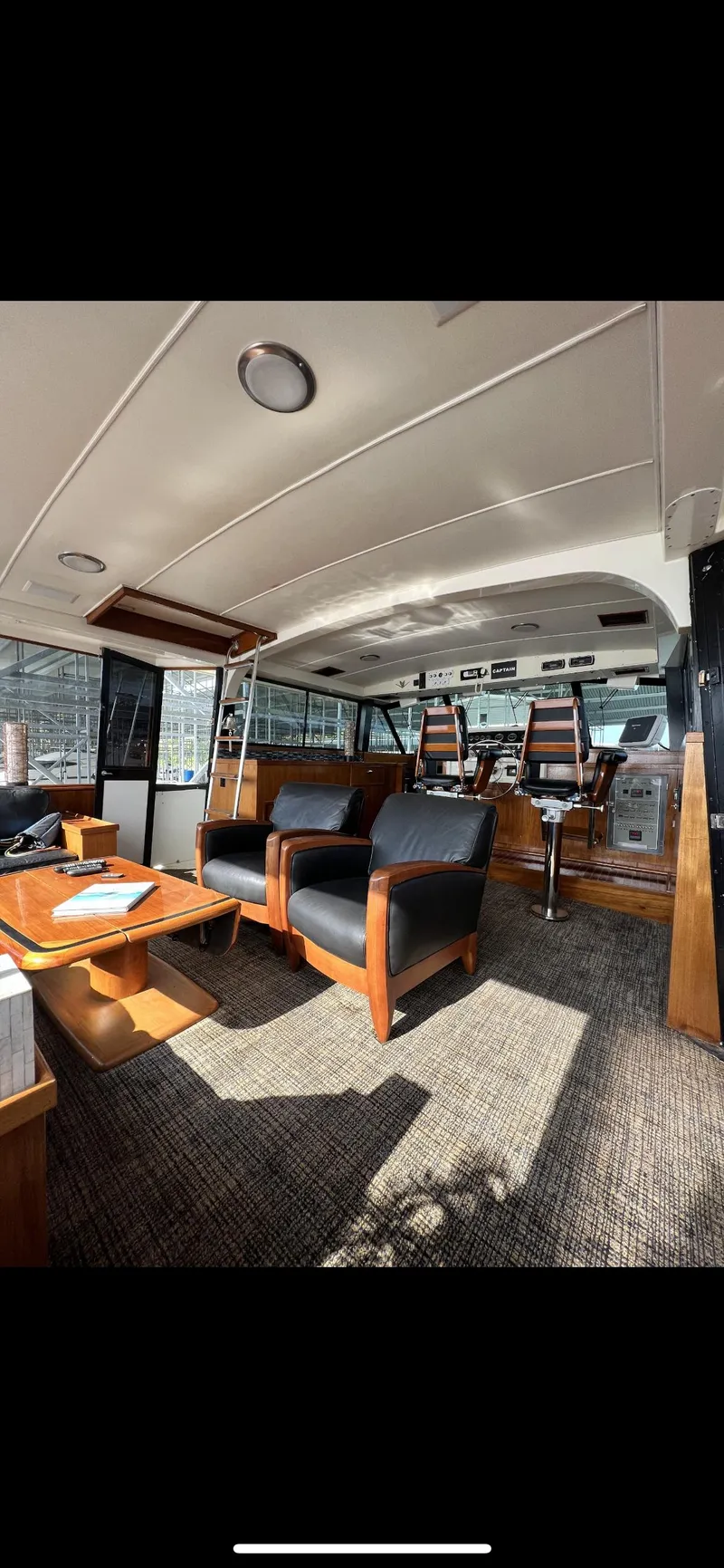 Slide: The Image of Interior of 1982 Bertram 58 Fly yacht with modern seating and navigation area. - 5