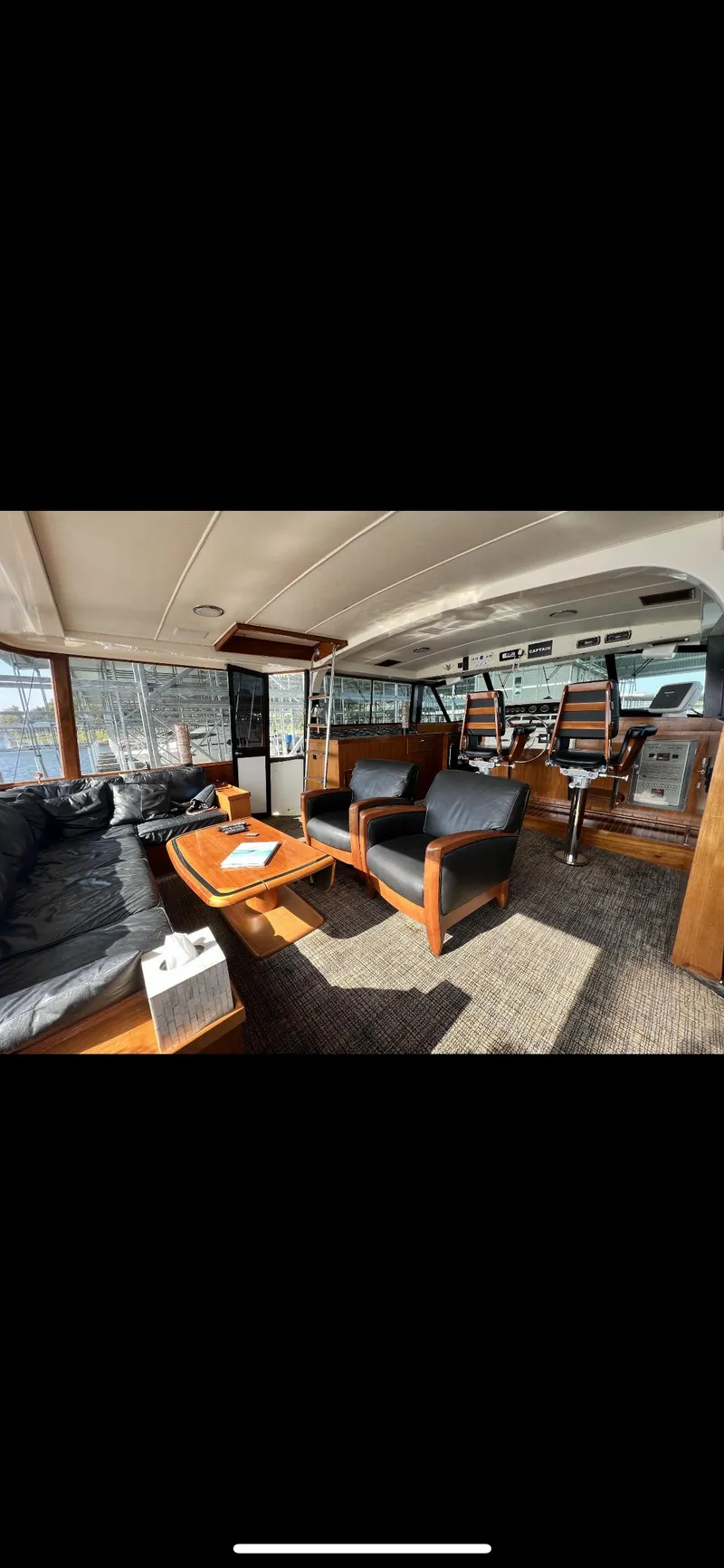 Slide: The Image of Interior of 1982 Bertram 58 Fly yacht with luxurious seating and wooden furnishings. - 6