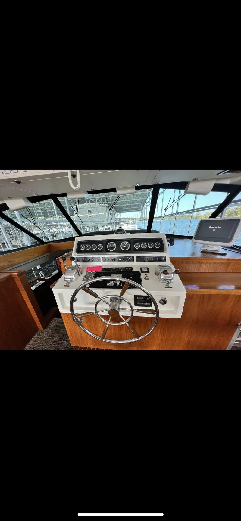 Slide: The Image of 1982 Bertram 58 Flybridge helm with steering wheel and control panel. - 8